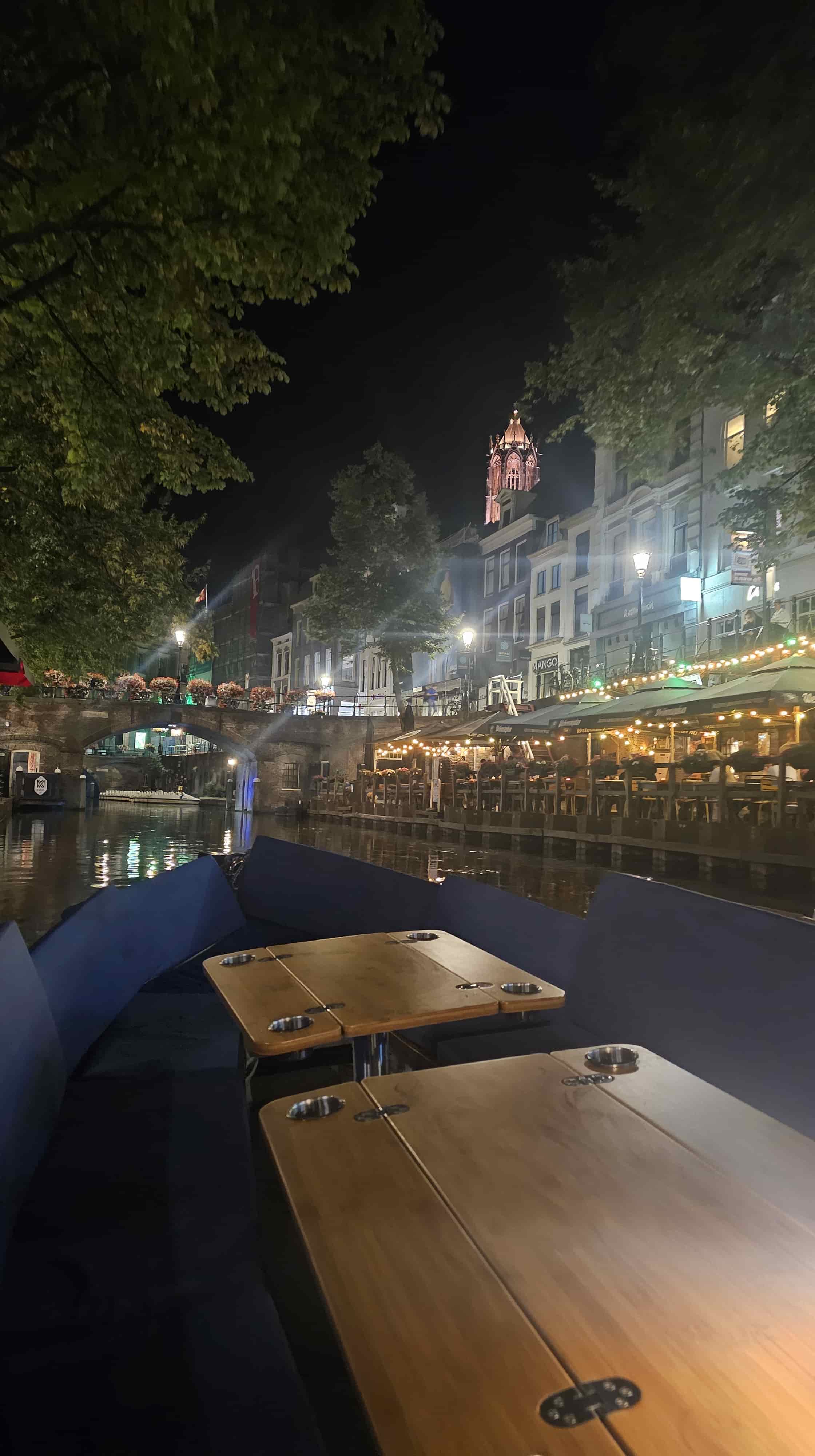 A cozy restaurant on the Oudegracht viewed from the water at night